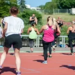 Criar uma Rotina de Atividades Físicas Sem Abandonar no Meio do Caminho - Pessoas participando de aula de atividade física em grupo ao ar livre