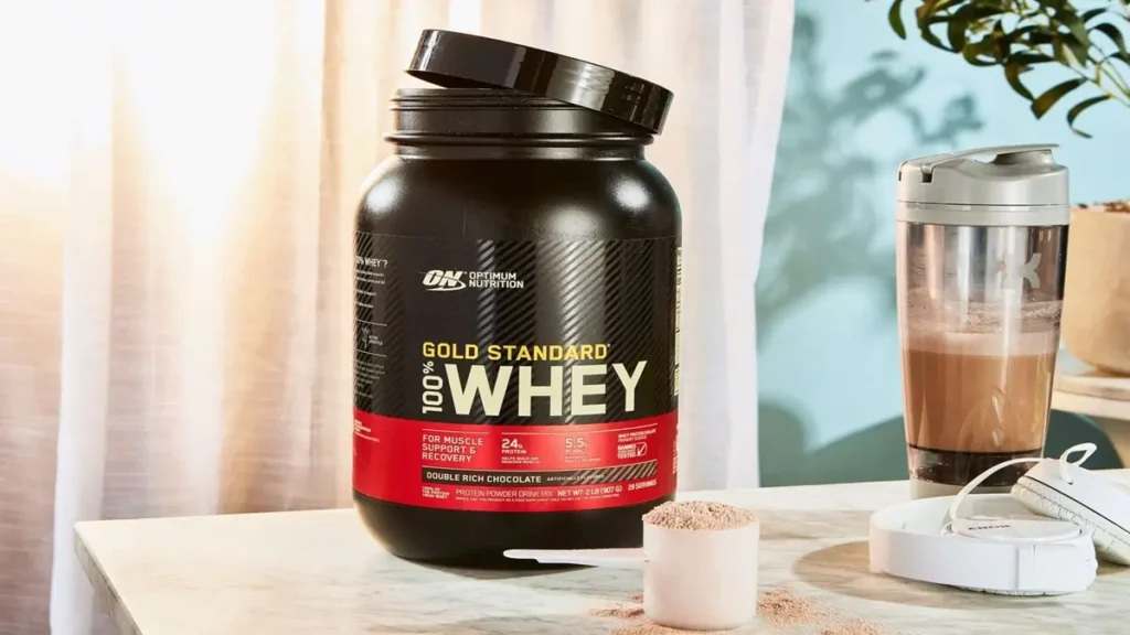 Pote de whey protein gold standard com shake preparado - suplementação proteica para atletas e praticantes de musculação