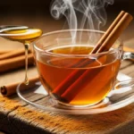 Xícara de chá de canela com pau de canela e mel em fundo de madeira, indicado para regular o açúcar no sangue naturalmente