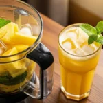 Copo de suco de abacaxi com hortelã e gelo em fundo claro