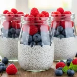 Potes de pudim de chia com camadas de frutas vermelhas e leite de coco.