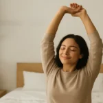 Mulher relaxando na cama ao amanhecer, simbolizando um sono restaurador e energia renovada.