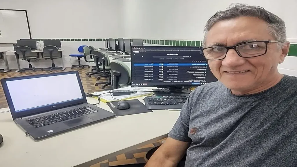 Um homem elegante e ativo de 60 e poucos anos trabalha confortavelmente em seu notebook.